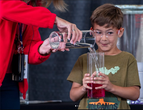child holding glass adult pouring liquid