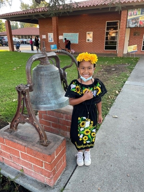 Student next to a Bell